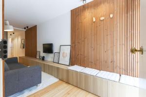 リスボンにあるSao Bento Classic by Homingのソファ付きのリビングルーム、木製の壁