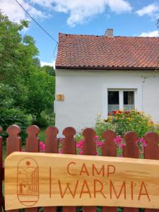 una cerca con un cartel que lee campamento karmaarma en Camp Warmia, en Stare Kawkowo