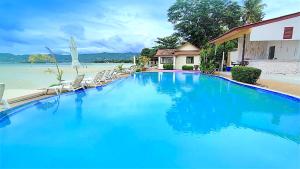 a large blue swimming pool next to a beach at Smile Samui Chaweng Beach Resort in Chaweng