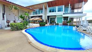 a large blue swimming pool in front of a house at Smile Samui Chaweng Beach Resort in Chaweng