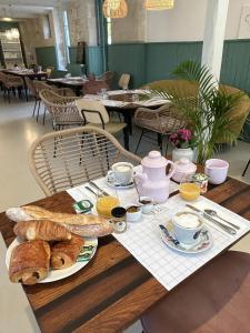 - une table avec petit-déjeuner composé de croissants et de jus d'orange dans l'établissement La Belle Vicoise, à Vic-sur-Aisne