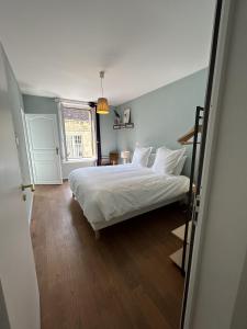 una camera da letto con un letto con lenzuola bianche e una finestra di La Belle Vicoise a Vic-sur-Aisne