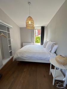 a bedroom with a large white bed and a table at La Belle Vicoise in Vic-sur-Aisne