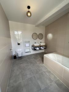 a bathroom with a tub and a toilet and a sink at La Belle Vicoise in Vic-sur-Aisne