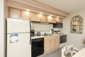 Una cocina con refrigerador blanco y gabinetes de madera. en Stoneridge 3BR Standard Condo, sleeps 8! condo, en Champion
