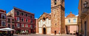 a tall brick building with a clock tower at Il Giardino di Giò in Iglesias