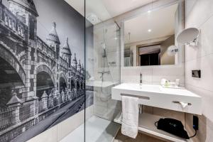 a bathroom with a white sink and a shower at NH Collection Antwerp Centre in Antwerp