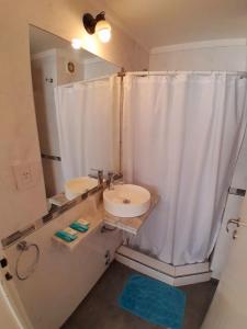 a bathroom with a white shower curtain and a sink at Edificio Recoleta in Buenos Aires
