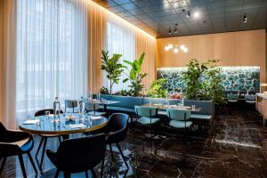 a restaurant with tables and chairs and plants at NH Collection Antwerp Centre in Antwerp