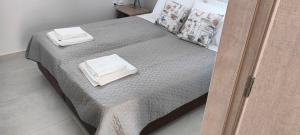 1 dormitorio con 1 cama con 2 toallas en Natageo en Loutraki