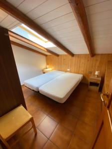 sypialnia z dużym łóżkiem na poddaszu w obiekcie Immobiliare Folgarida Apartments w mieście Folgarida