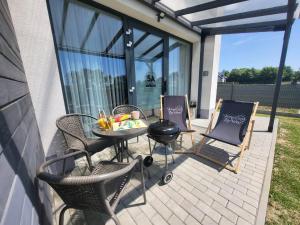a patio with chairs and a table and a grill at Słoneczne Zacisze Las obok Zatora in Las