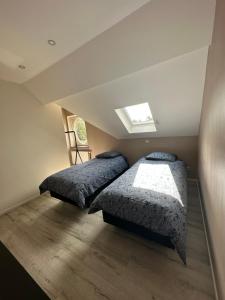 a bedroom with two beds and a skylight at The 75 renovated work or holiday home in Comines