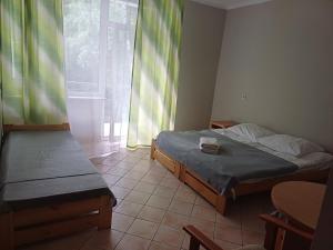 a small room with two beds and a window at Hotel Ameliówka in Masłów