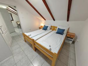 a bedroom with a large bed with blue pillows at Apartmani Todorovic in Vinci