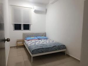 um quarto com uma cama com almofadas azuis em METROPOL SERVICED APARTMENT at Bukit Mertajam, Pulau Pinang em Bukit Mertajam