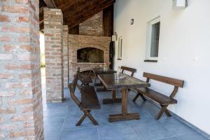 a dining room with a table and a brick fireplace at Kuća za odmor Bosut in Vinkovci