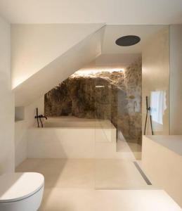 ein weißes Bad mit einem WC und einer Treppe in der Unterkunft Cabana La Roca in La Roca