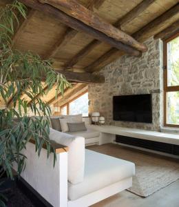 ein Wohnzimmer mit einem weißen Sofa und einem TV in der Unterkunft Cabana La Roca in La Roca