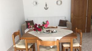 a dining room table and chairs with flowers on it at Blue Paradise Apartment in Lukovë