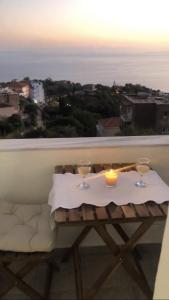 a table with two glasses and a candle on a balcony at Blue Paradise Apartment in Lukovë