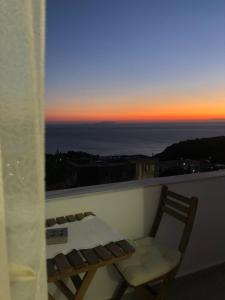 a chair sitting on a balcony with a sunset at Blue Paradise Apartment in Lukovë +6 photos