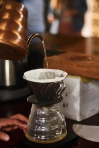 Una cafetera está vertiendo café en una taza en Hotel La Palma y El Tucán, en Zipacón