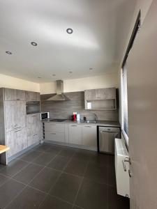 uma cozinha com armários brancos e piso em azulejo em The 75 renovated work or holiday home em Comines