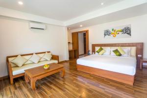 a bedroom with a bed and a couch at Aura Samui Best Beach Hotel - SHA Plus in Lamai