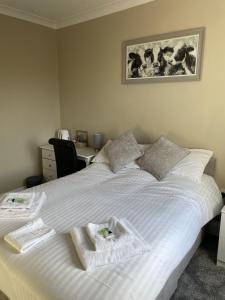 a bedroom with a large white bed with towels on it at The Seven Stars in Durham