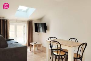 ein Wohnzimmer mit einem Tisch, Stühlen und einem Sofa in der Unterkunft Le Cypri'Deux by iZiLi *Confort*Calme* in Poitiers