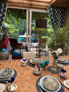 una mesa de madera con platos y platos. en Chambres d'hôtes - Le Nador, en Meurchin