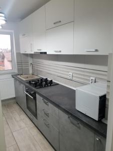 a kitchen with white cabinets and a stove top oven at Sya home in Braşov