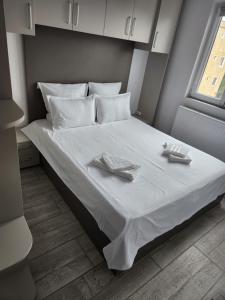 a bed with two napkins and two dishes on it at Sya home in Braşov