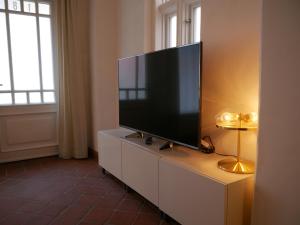 リューネブルクにあるStay Hygge - Zentrales Altstadt-Apartment in Lüneburg mit kostenfreiem Parkplatzの白いキャビネットの上に置かれた薄型テレビ