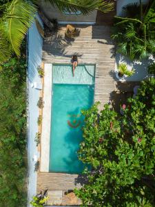 an overhead view of a man jumping into a swimming pool at Dar Mar Hostel & Coworking in Paje