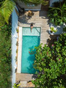 an overhead view of a man jumping into a swimming pool at Dar Mar Hostel & Coworking in Paje