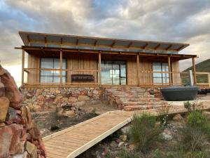 a wooden house with a wooden bridge in front of it at Riverbend Farm in Robertson