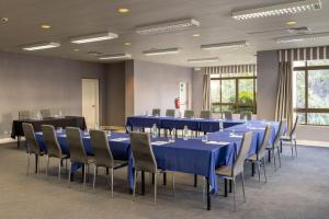 a conference room with blue tables and chairs at Clube do Lago Hotel in Estoril