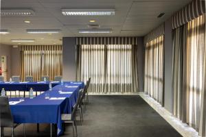 a conference room with blue tables and chairs and windows at Clube do Lago Hotel in Estoril