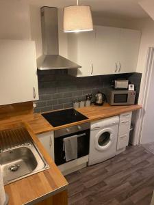 uma cozinha com um lavatório e um fogão forno superior em Cosy 1 Bed Home @Stevenage em Shephall