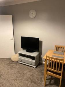 ShephallにあるCosy 1 Bed Home @Stevenageの白いエンターテイメントセンターの上に座って薄型テレビを設置