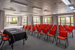 a conference room with red chairs and tables in it at Clube do Lago Hotel in Estoril