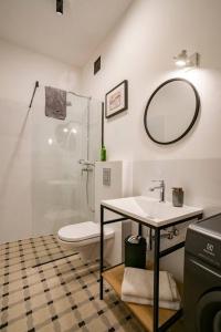 een badkamer met een wastafel, een toilet en een spiegel bij Cozy Studio 5 minut by Warsaw East in Warschau