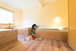 a room with two beds and a mop on the floor at Ferienpark am Darß - Ferienhaus 7 in Fuhlendorf