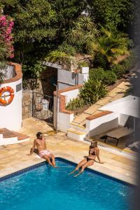 two people are sitting in a swimming pool at Clube do Lago Hotel in Estoril