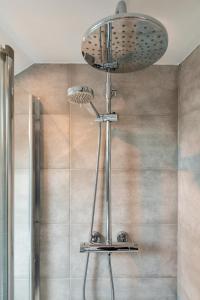 La salle de bains est pourvue d'une douche avec un pommeau de douche. dans l'établissement Fulham Studio Apartments, à Londres