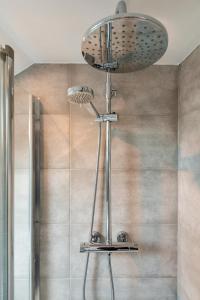 a shower with a shower head in a bathroom at Fulham City Suites in London