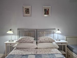 a bedroom with a bed with two lamps on two tables at Szafranówka in Władysławowo