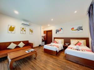 Habitación de hotel con 2 camas y mesa en Aura Samui Best Beach Hotel - SHA Plus en Lamai
